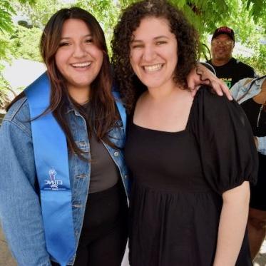 two women standing and smiling