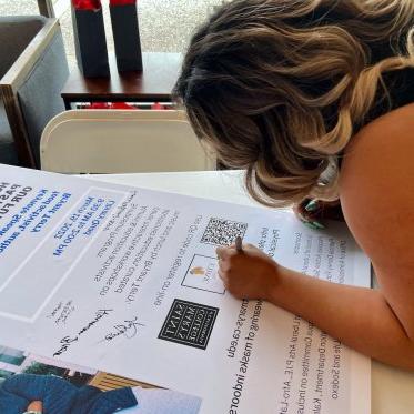 woman writing on a big poster