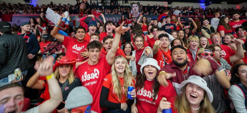 Students cheering wearing Gaels shirts at a basketball game