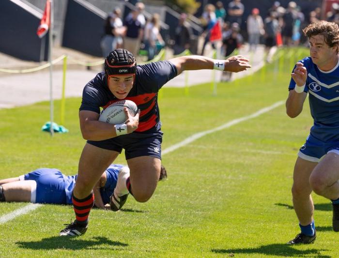 Men's rugby player Dominic Besag runs past BYU defenders, April 2024